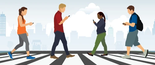 image of pedestrians using a cellphone in a crosswalk